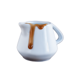 A small ceramic pitcher with coffee syrup dripping down the side.